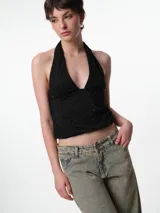 Top negro con escote halter, confeccionado en tejido elastizado con pequeños apliques brillantes distribuidos por toda la prenda.