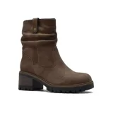 Bota de caña media confeccionada en cuero, con diseño de efecto arrugado en la parte superior y detalle de tira con botón a presión. Cuenta con taco cuadrado de altura media y suela track dentada.