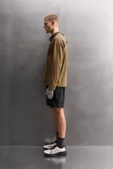 Camiseta de algodón de corte relajado (relaxed fit), color verde oliva, con cuello redondo, manga larga y bolsillo plastrón con cierre de cremallera en el pecho.