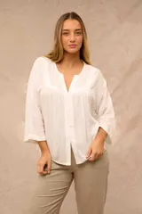 Blusa color crudo de mangas 3/4, escote en V con abotonadura frontal y sutiles pliegues en la parte delantera.