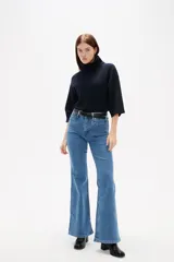 Pantalon jean de corte flare y tiro alto, con bolsillos delanteros tipo parche.