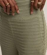 Pantalón recto color verde oliva, confeccionado en malla texturizada con cintura elástica y bolsillos laterales.
