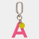 Llavero con dije en forma de letra A color rosado y pequeño dije circular amarillo con logo de la marca grabado. Incluye gancho metálico tipo mosquetón.