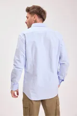 Camisa blanca de manga larga con cuello clásico y cierre frontal con botones.
