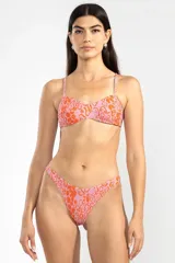 Conjunto de bikini con estampado animal print en tonos rosado y naranja. El corpiño es de estilo triángulo con breteles finos y la bombacha es de tiro bajo con corte en V.