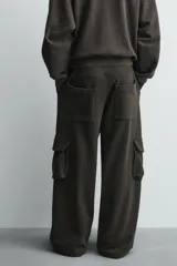 Pantalón cargo de corte relajado con efecto lavado, confeccionado en tejido de algodón. Presenta cintura elástica, bolsillos laterales de plastrón con solapa y bolsillos delanteros.