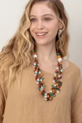 Vestido midi de lino color beige, de corte holgado y silueta acampanada. Cuenta con cuello redondo, mangas cortas amplias, bolsillos laterales y detalles de recortes horizontales en la falda con terminación asimétrica más larga en la parte trasera.