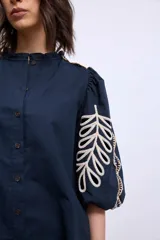 Blusa azul marino con cuello mao, mangas 3/4 abullonadas y bordados en color crema en hombros y mangas.
