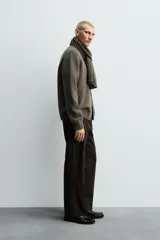 Cárdigan de punto tejido en lana, color marrón oscuro/verde oliva, de calce relajado (regular fit). Presenta cuello redondo, manga larga y cierre frontal de botonadura con botones oscuros.