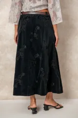 Pollera larga de pana color chocolate, con diseño de tablas frontales y bordados florales en toda la superficie. Cuenta con cintura con pasacintos.