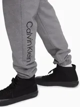 Pantalón tipo jogger de algodón con cintura elástica, bolsillos laterales y traseros, y logo de la marca bordado.