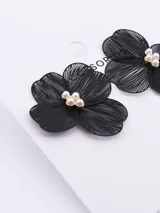 Aros colgantes con forma de flor color negro con centro de perlas.