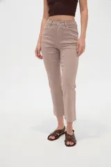 Pantalón jean de tiro alto y corte recto, color blanco, con bolsillos laterales y traseros, y terminación desmechada en los tobillos.