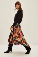 Falda midi de viscosa con estampado abstracto multicolor en tonos vibrantes como fucsia, violeta, verde y naranja. Presenta un diseño fluido con una abertura frontal que permite mayor movimiento.