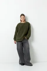 Buzo negro de tela tipo teddy, de manga larga y cuello redondo. Presenta recortes de nylon en mangas y laterales.