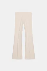 Pantalón de vestir color rosado, tiro bajo, con corte acampanado (flare) y costuras laterales marcadas. Cierre frontal con botón interior y gancho.