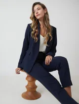 Pantalón sastrero slim negro de tiro alto, con pretina anatómica, pinzas verticales frontales y cierre oculto. Tiene bolsillos laterales inclinados y pinzas traseras para un ajuste favorecedor.