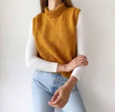 Chaleco tejido a mano color beige con cuello alto y sisas amplias.