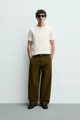 Camiseta de manga corta con cuello panadero y cierre frontal de tres botones. Presenta una textura acanalada y un corte regular fit.