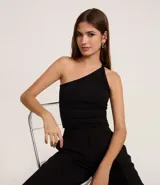 Top ajustado negro de punto roma, con diseño asimétrico de un solo hombro y detalle de bretel torcido en el hombro descubierto.