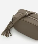 Cartera bandolera pequeña de diseño estructurado en color topo, con cierre de cremallera metálico y detalle de borla larga colgante. Cuenta con correa ajustable y forro interior.