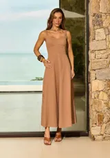Vestido largo color marrón de corte evasé, con escote cuadrado, tirantes anchos y detalles bordados sutiles en la zona de la falda.