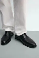 Zapato tipo oxford de vestir en color marrón oscuro, con diseño de puntera reforzada y cordones al tono.