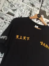 Remera negra de manga corta con estampado de letras japonesas en color naranja.