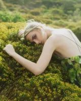 Vestido corto con estampado floral en tonos verdes y negros, escote en V y tirantes finos.