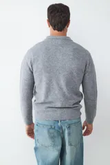 Sweater de punto suave color gris, con cuello polo y cierre frontal de tres botones. Confeccionado en un tejido abrigado.