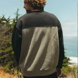 Buzo de cuello redondo Maui and Sons, con diseño de bloques de color en negro y gris. Presenta puños y ruedo acanalados, con un pequeño parche con el logo de la marca en el pecho.