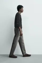Jeans regular fit de denim de algodón en color gris con efecto lavado, tiro medio, diseño de cinco bolsillos y cierre frontal con botones.