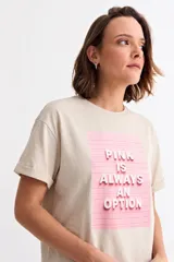 Remera de algodón color beige con cuello redondo y mangas cortas con dobladillo. Presenta un estampado frontal rectangular en color rosa con el texto en relieve 'PINK IS ALWAYS AN OPTION'.