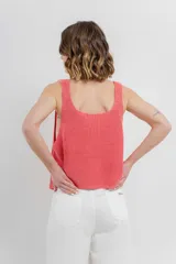 Chaleco celeste de punto con escote en V y cierre frontal con botones. Tejido calado y corte holgado.