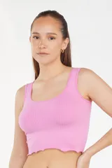 Top corto de bretel ancho, color rosa, con textura acanalada y terminación ondulada en el ruedo.