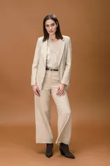 Pantalón sastrero de corte ancho y tiro alto, con diseño de líneas limpias, bolsillos laterales y cierre frontal con botón. Presenta una caída fluida y estructura amplia.