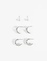 Set de tres pares de aros plateados: un par de aros tipo perla, un par de aros tipo argolla lisa y un par de aros tipo argolla con textura.