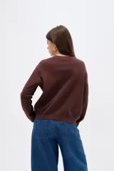 Sweater de viscosa con diseño color block, combinando frente negro con mangas y laterales en tono marrón. Presenta cuello redondo a la base y mangas largas.