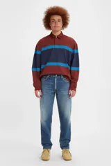 Jean de corte relajado y pierna cónica, con tiro medio y cierre de botones. Presenta un lavado azul medio con efecto desgastado.