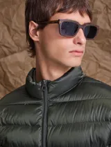 Campera puffer de plumas en color azul marino, con cierre frontal, cuello alto y diseño acolchado horizontal.