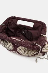 Bolso de mano tipo sobre con estructura rígida, decorado con un patrón geométrico de rombos bordados en cuentas color bordó y detalles brillantes en el interior. Cuenta con doble asa rígida integrada y cierre mediante botón imantado.