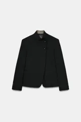 Blazer de cuello alto y manga larga con cierre frontal de botones metálicos en relieve. Presenta aberturas en los puños con botones y falsos bolsillos de vivo en el delantero.