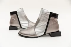 Botín de cuero negro con apliques dorados, punta almendrada, cierre lateral y taco cuadrado.