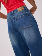 Jean de corte wide leg con tiro medio, confeccionado en denim de algodón en tono azul medio con efecto lavado.