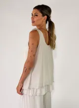 Top de viscosa color marrón tostado, sin mangas, con escote redondo y detalle de lazos para anudar en los hombros. Presenta un diseño de capas con volados en el ruedo.