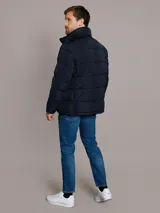 Campera puffer azul marino de Calvin Klein, de diseño acolchado con cuello alto y cierre frontal de cremallera. Incluye bolsillos laterales con cierre y chaleco interior desmontable.