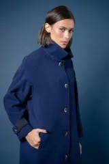 Tapado de corte recto con estampado de pata de gallo en tonos azul y gris. Presenta cuello camisero y detalles en los puños en color negro, cierre frontal con botones y bolsillos laterales.