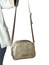 Bandolera Chabas modelo Baby de cuero natural con textura en relieve tipo cocodrilo, color dorado. Cuenta con cierre de metal, correa de cuero regulable y detalle de placa metálica con la marca grabada en el frente.
