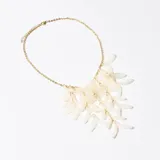 Collar dorado con cadena de eslabones y colgante con múltiples pétalos blancos.