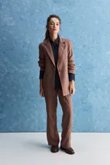 Blazer de corte sastrero con silueta relajada, solapas tradicionales, cierre frontal de un botón y bolsillos de vivo.